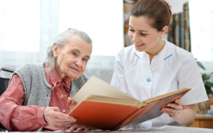 caregiver and old woman reading book